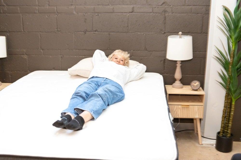 A woman lying on her back on the Titan Plus Luxe mattress