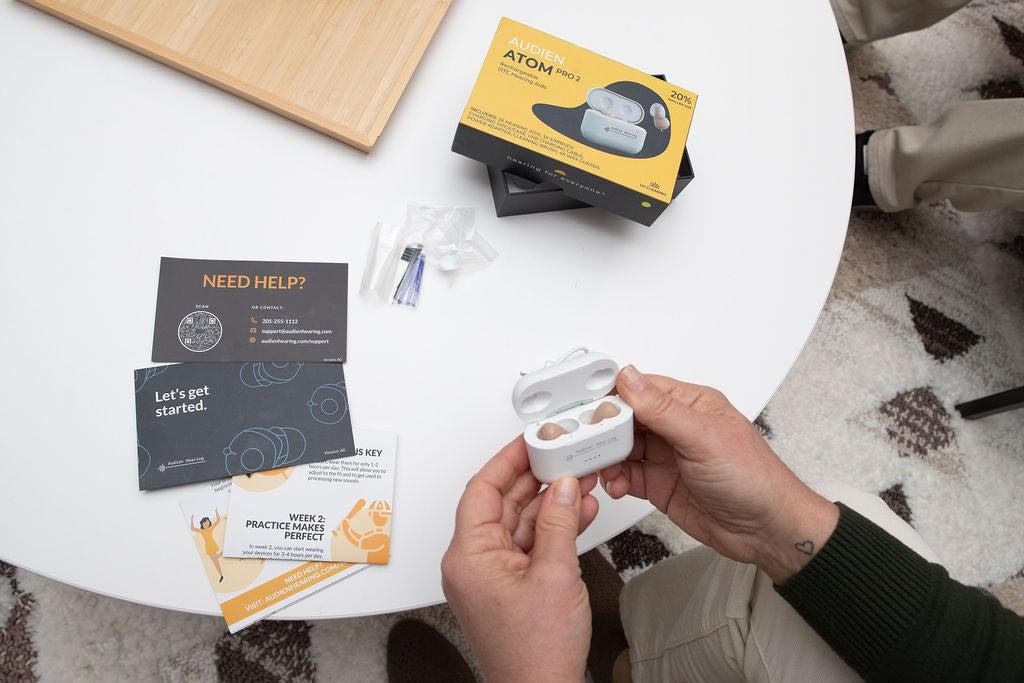 A person opening the Audien Atom Pro 2 case