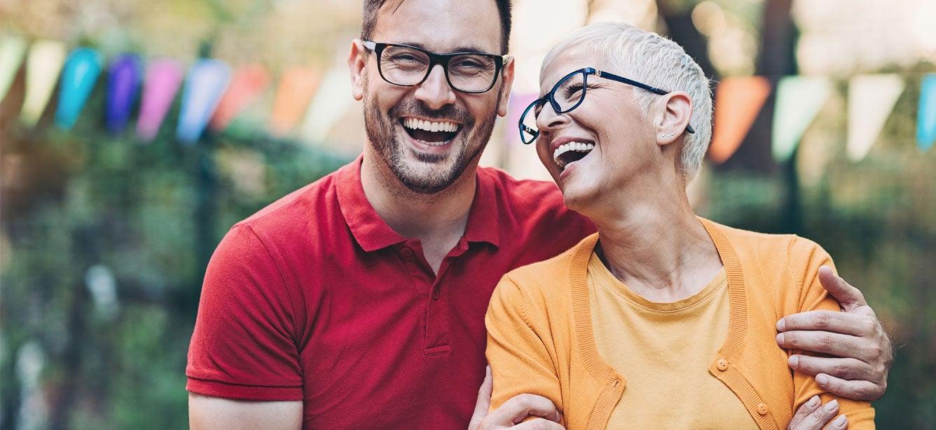 Two people joyfully laughing together outdoors.