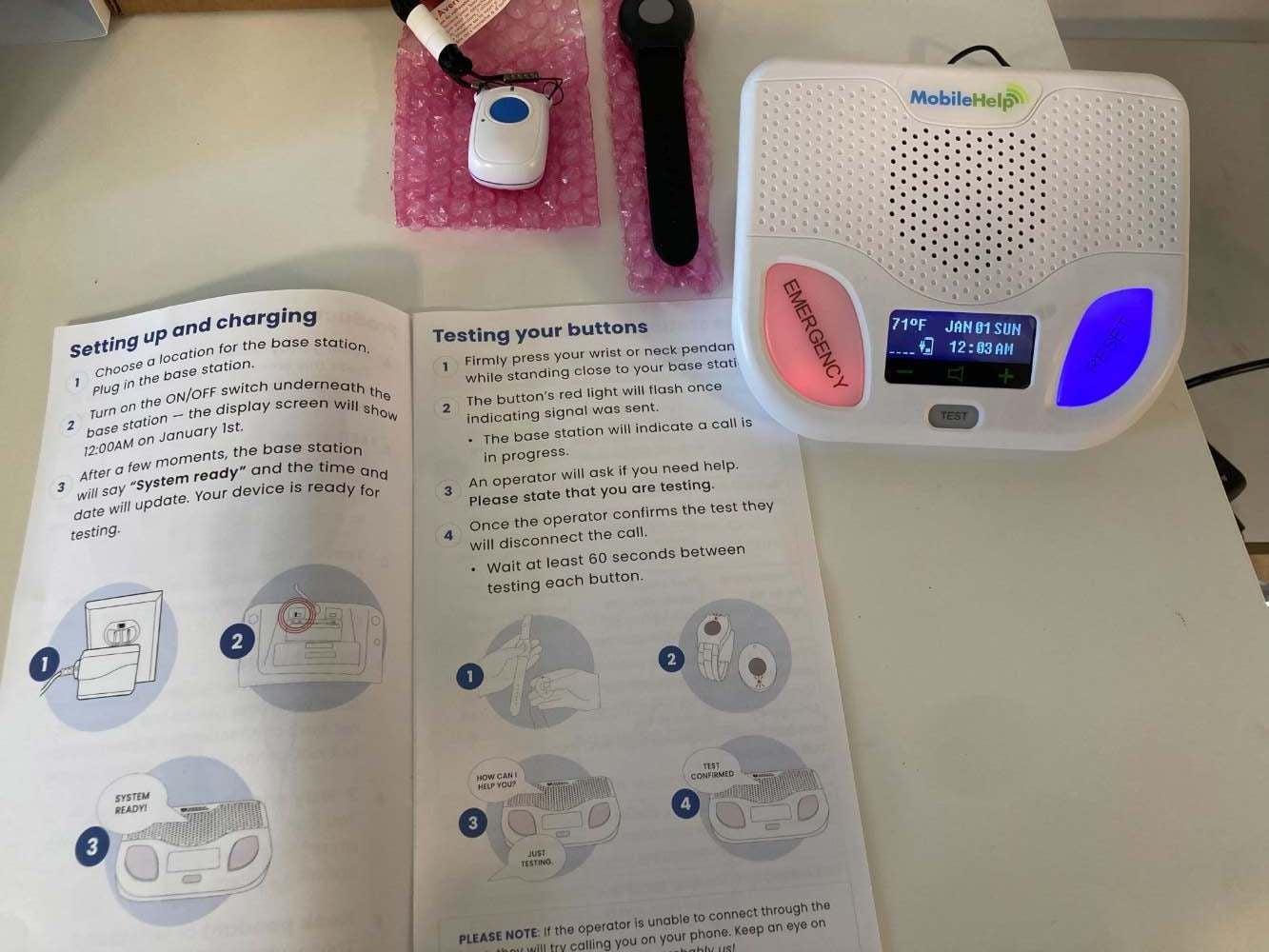 MobileHelp Classic Cellular on a table with a user manual next to it