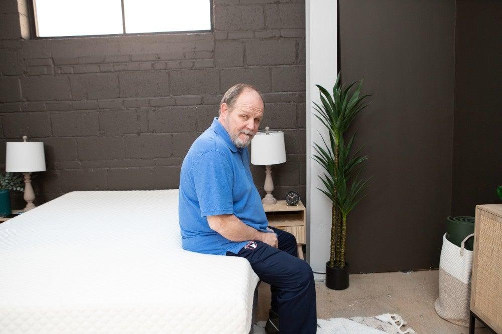 A man sitting on the side of the Nolah Signature mattress