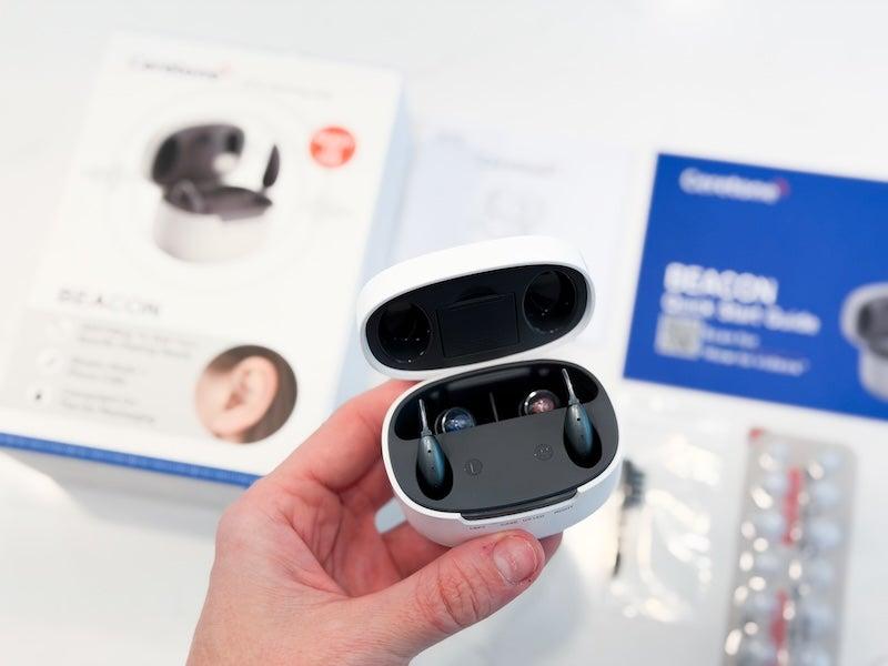 hand holding Ceretone hearing aids in case