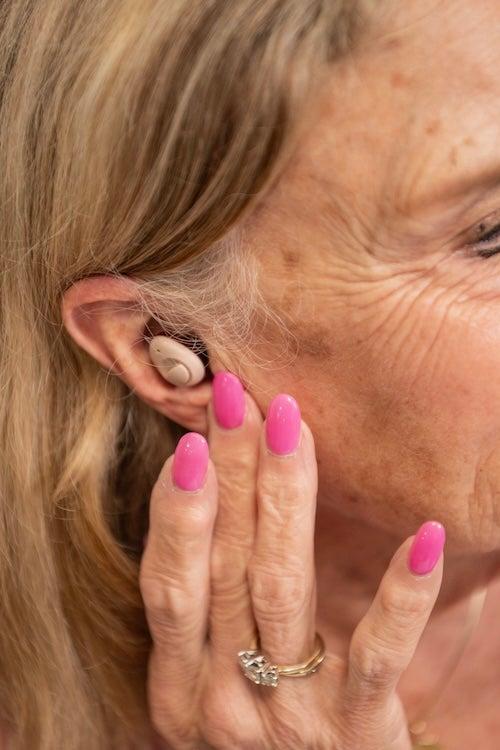 A woman wearing the Ceretone Torch hearing aids