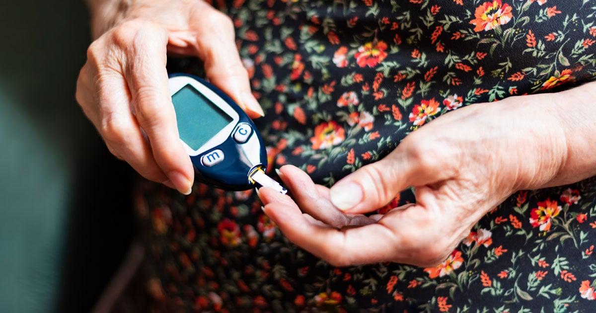 A senior woman is monitoring her glucose levels.