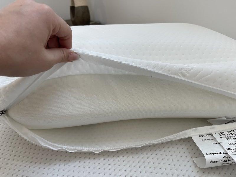 A hand holding the Tempur-Symphony pillow open to show its interior