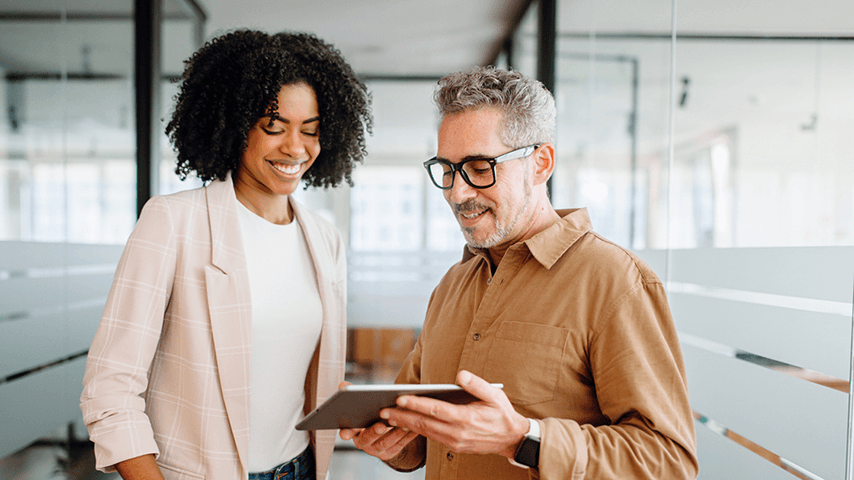 woman and man in office looking at tablet
