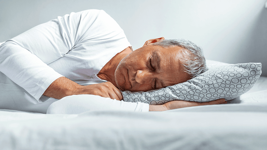 older white man with gray hair asleep on his side