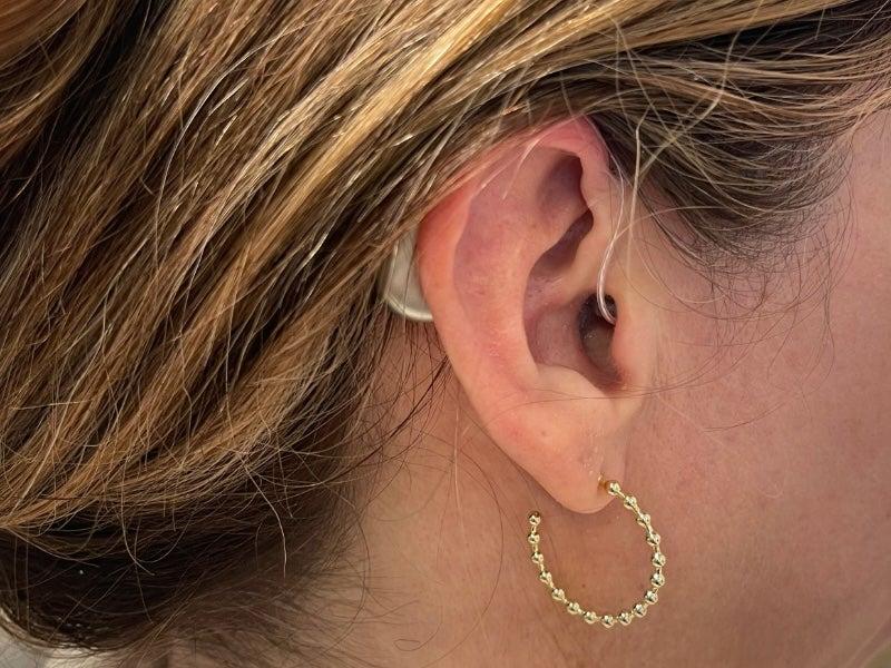 A woman wearing the Elehear Beyond hearing aids