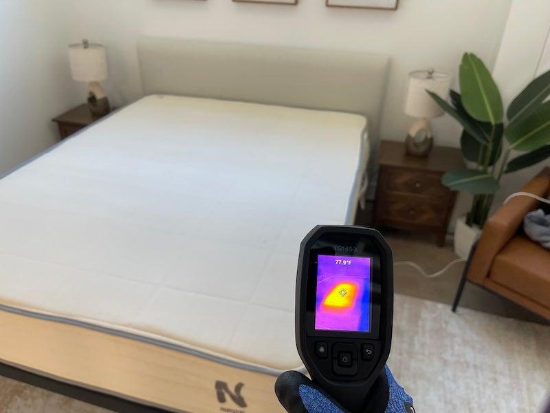 A heat gun shows a reading of 77.9 degrees F for the Nolah Natural latex mattress