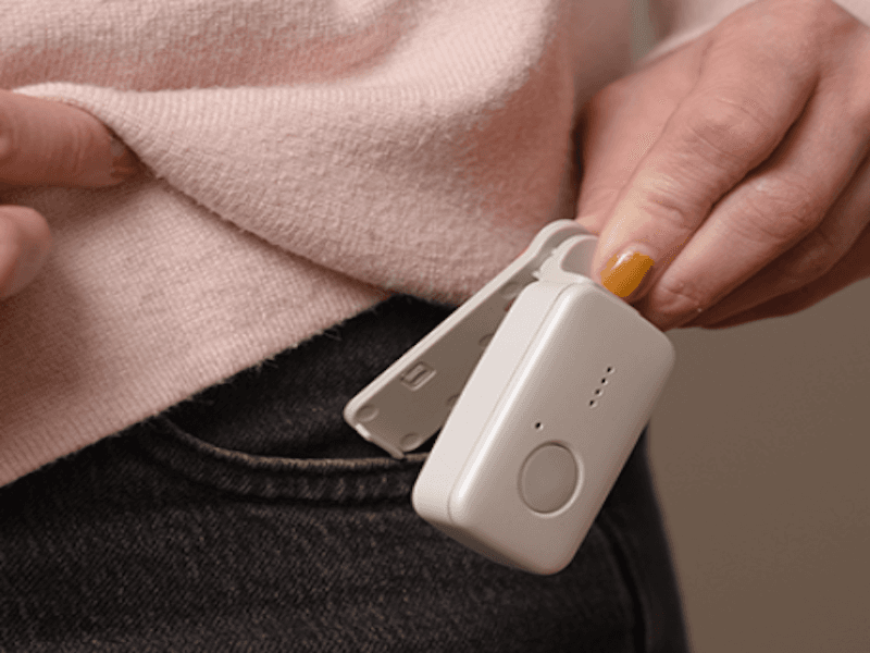 Medical Guardian Mini being clipped onto a pair of jeans.