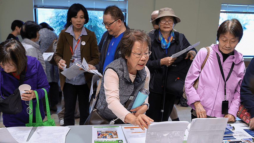 older adults perusing information at a falls prevention event table