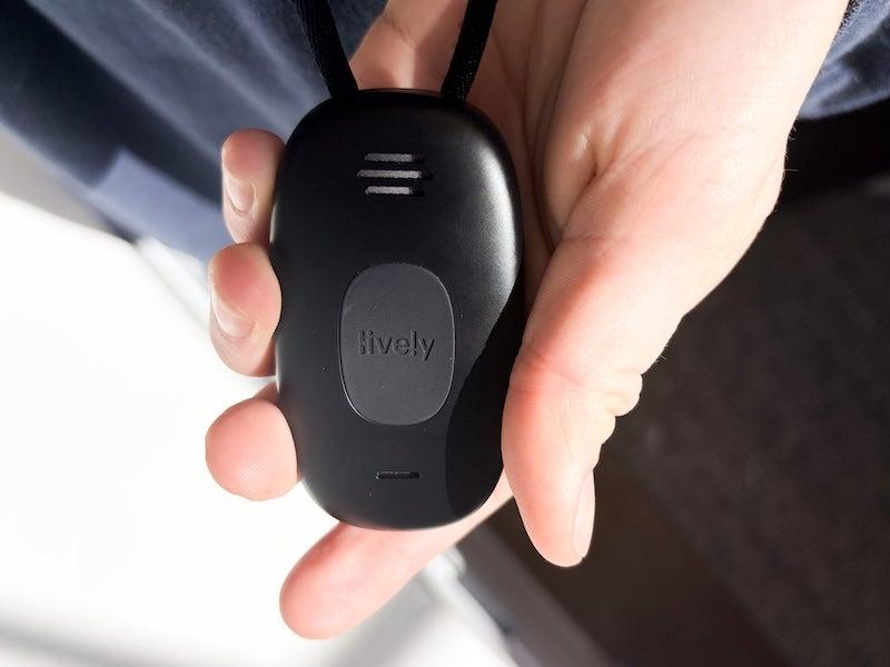 A hand holding the Lively Mobile2 medical alert system