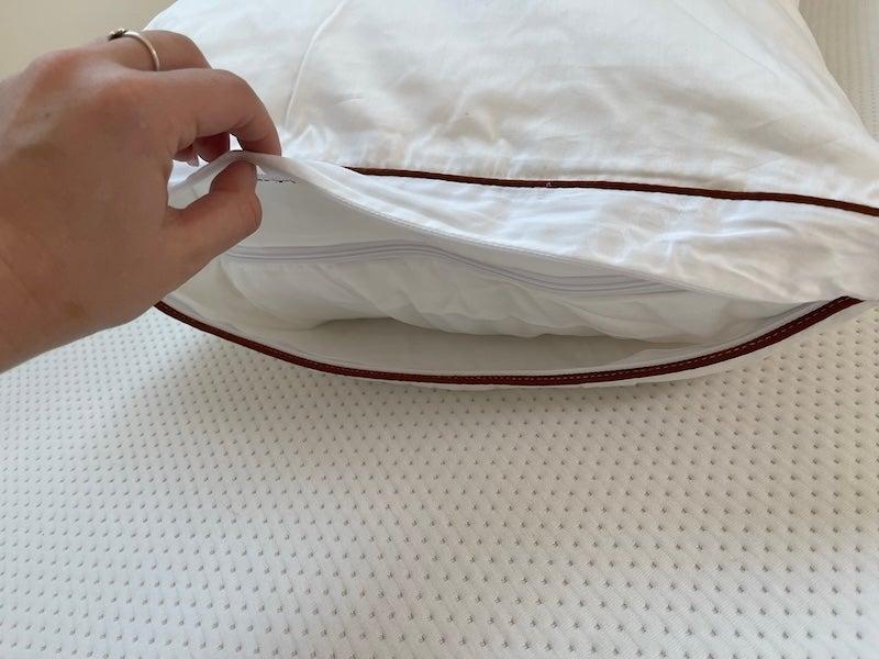 A tester touches the second cover of the Saatva Latex pillow.