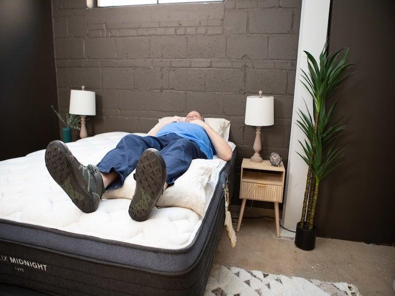 A man lying on his back on the Helix Midnight Luxe mattress