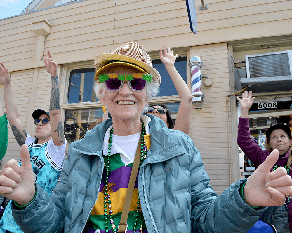 Smiling older woman and other Mardi Gras parade revelers
