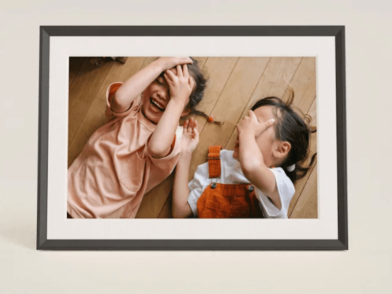 Framed photo of two children playing peek-a-boo”