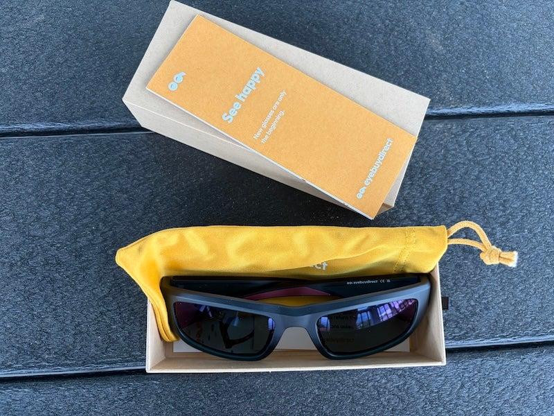 Polarized Eyebuydirect sunglasses sit inside a cheerful yellow case