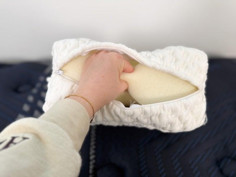 A hand reaches into the side of the Helix knee pillow and squeezes the interior foam
