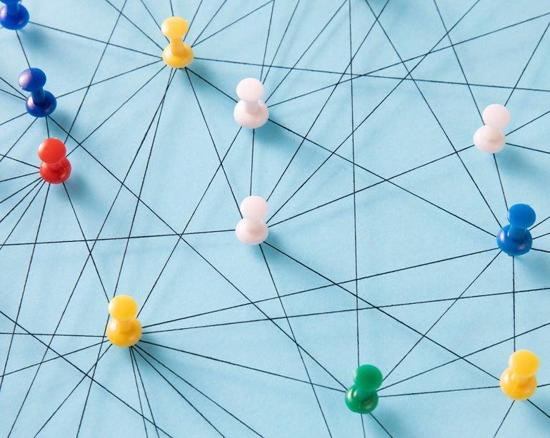 A conceptual idea of a network through various pins connected by lines on a board.