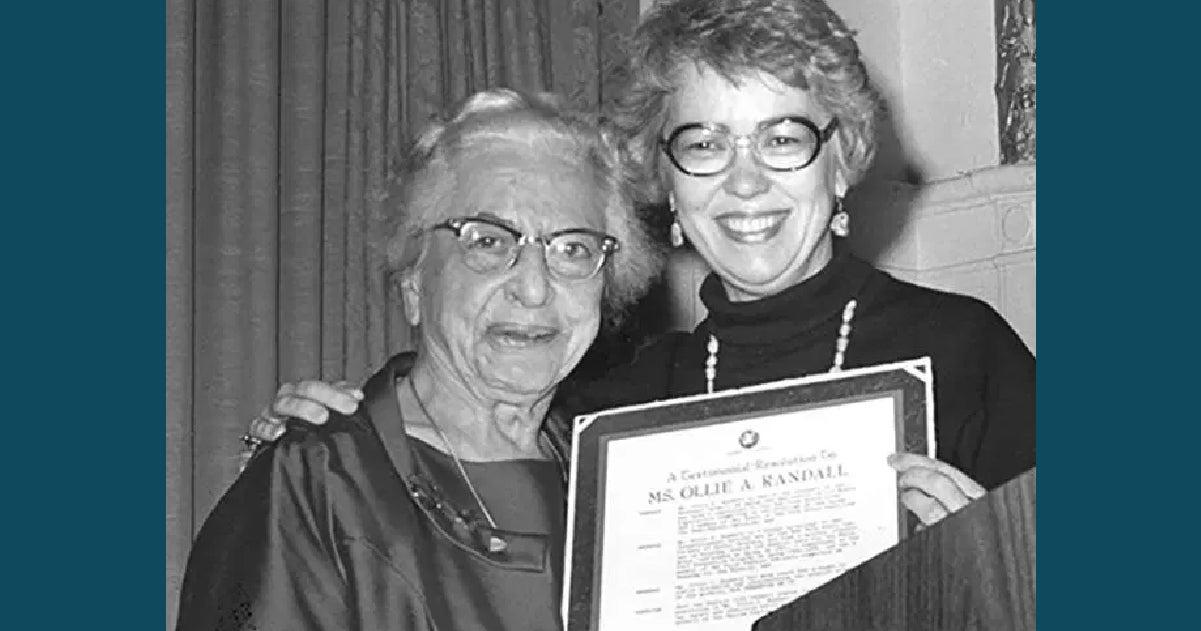 Ollie Randall receiving award from smiling woman