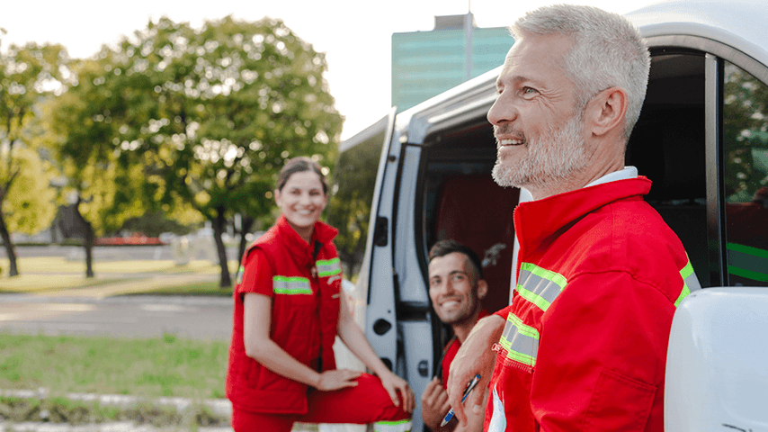 smiling EMS workers next to an ambulance