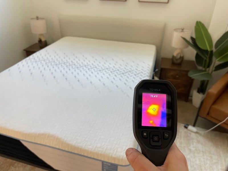 A heat gun reading 76.4 degrees F is aimed at the Nectar Classic Hybrid mattress