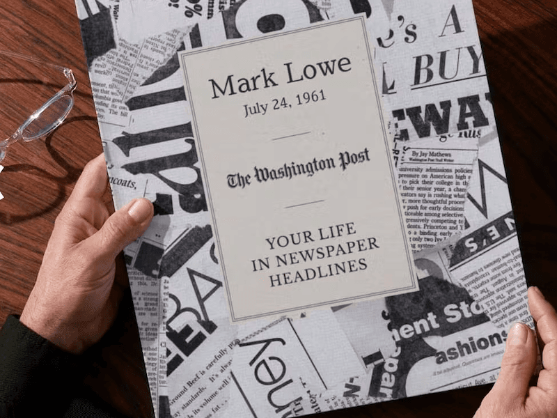 Hands hold a book covered with newspaper print with the title “Your Life in Newspaper Headlines”