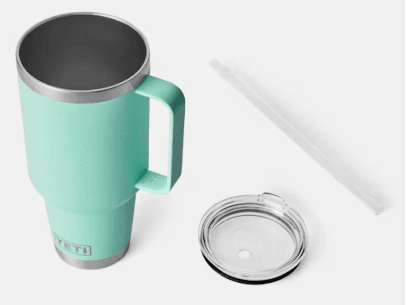 Mint green travel mug with narrow bottom and YETI logo, displayed with straw and lid to the side