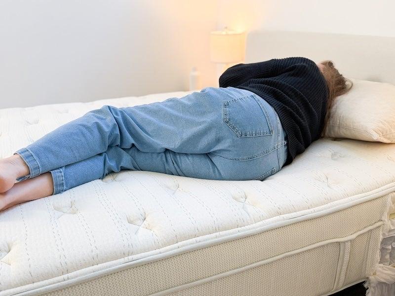 A woman lies on her side on the Leesa Natural mattress