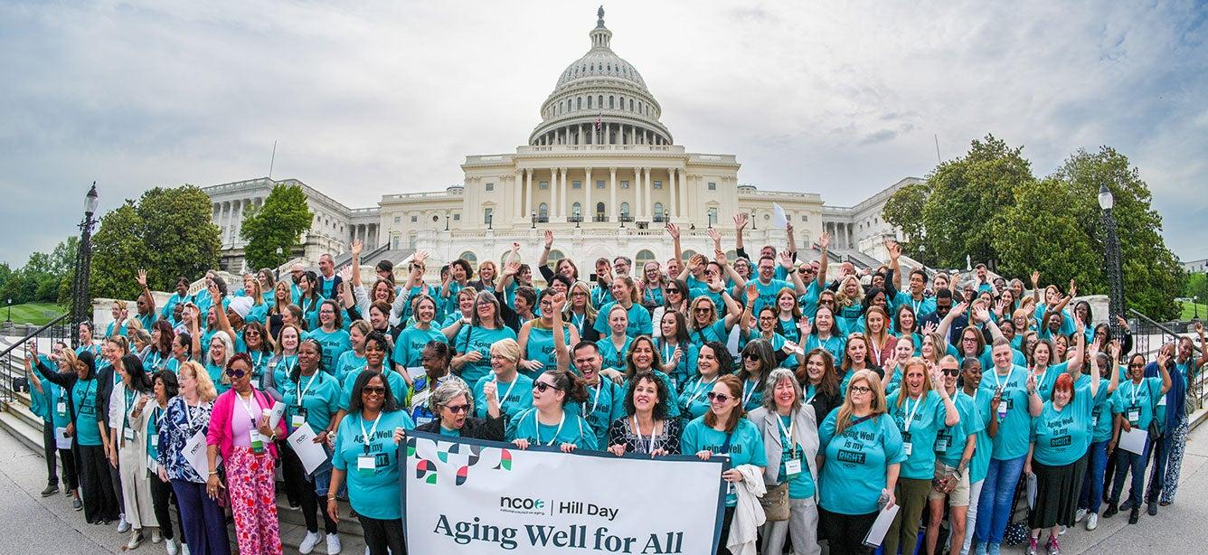 A large, diverse group of people is gathered on the steps of the Capitol building, all wearing matching teal shirts with the slogan "Aging Well is my RIGHT." They are part of the Age+Action 2024 Conference Hill Day event organized by NCOA. The participants are smiling, cheering, and raising their hands in solidarity, holding a banner that reads "Aging Well for All." The Capitol dome is prominently visible in the background, signifying the advocacy and unity of the group in promoting the rights and well-being of older adults.