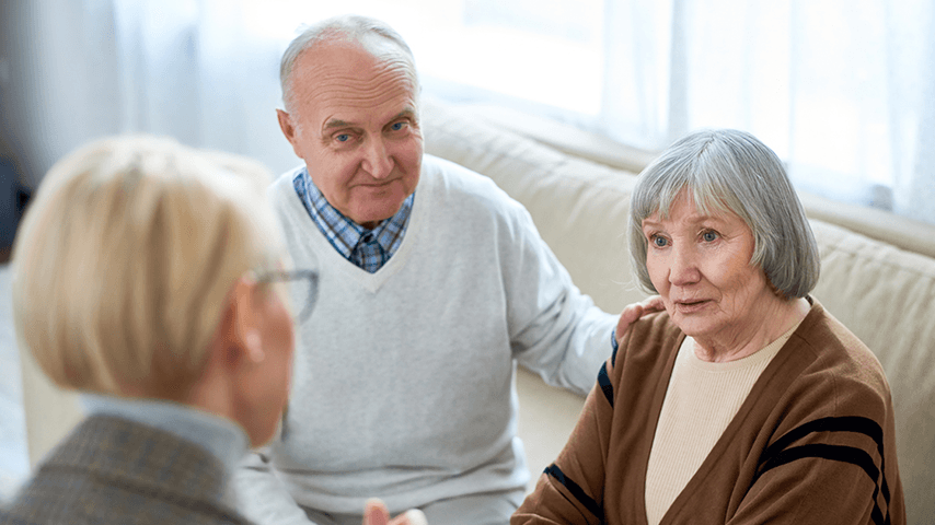 older man and woman talking to counselor