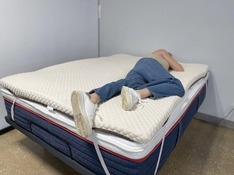 A person lying on their side on the Nolah mattress topper