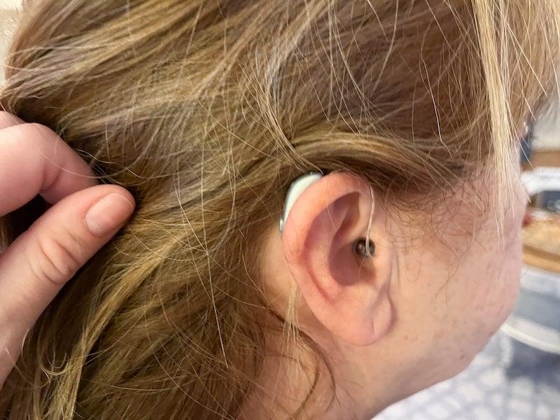 A woman wearing the Jabra Enhance Select 700 hearing aid