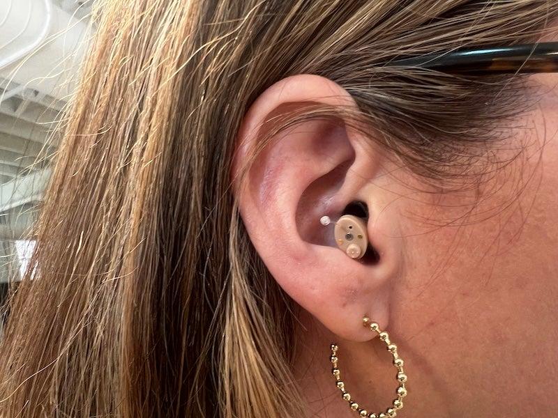 The MDHearing Neo XS hearing aid in a woman’s ear.