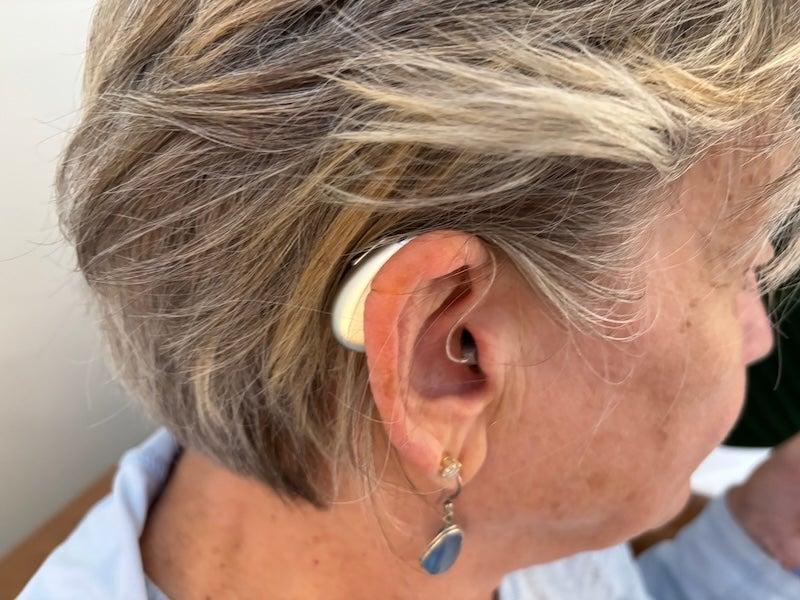 A woman wearing the Elehear Beyond Pro hearing aids