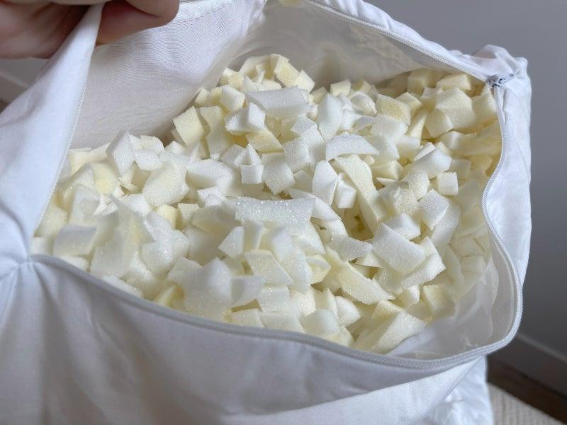 A person displays the interior fill of a Silk & Snow pillow, which is tiny pieces of memory foam.