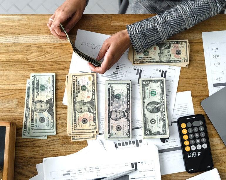 Senior hands are counting out money, calculating to ensure that ends can be met.