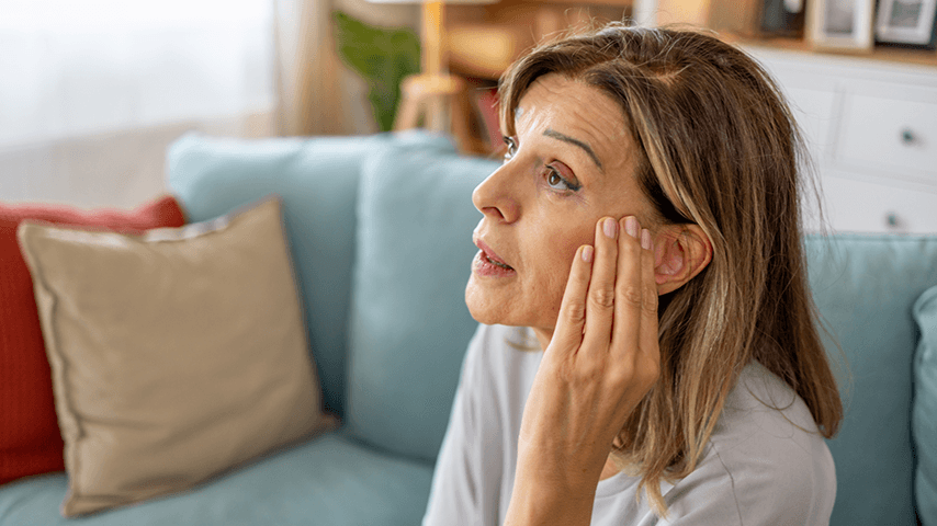 woman touching her face near her ear