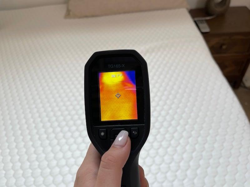 A heat gun pointed at the Bear Pro mattress topper reads 80.7 degrees.
