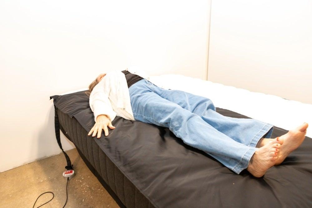 A woman lies on her back on the Titan Plus mattress on top of a pressure map