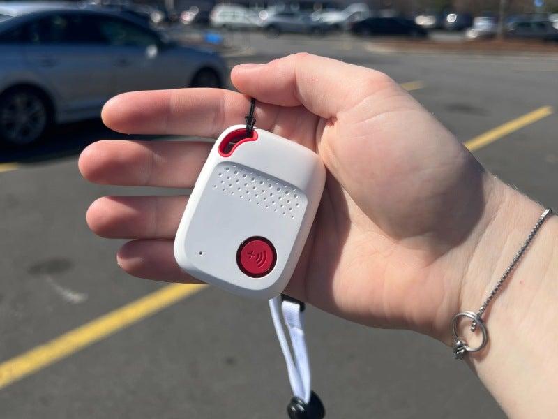 Bay Alarm SOS All in One in a person’s hand in a parking lot