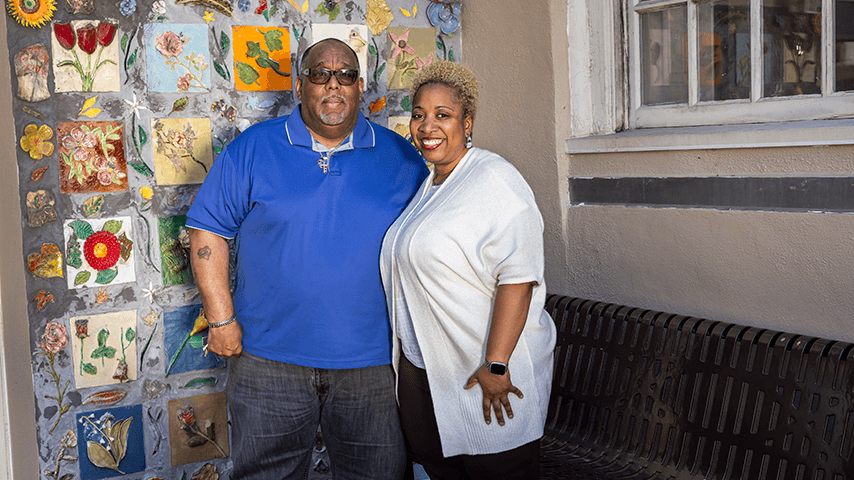 two smiling staff members outside a senior center