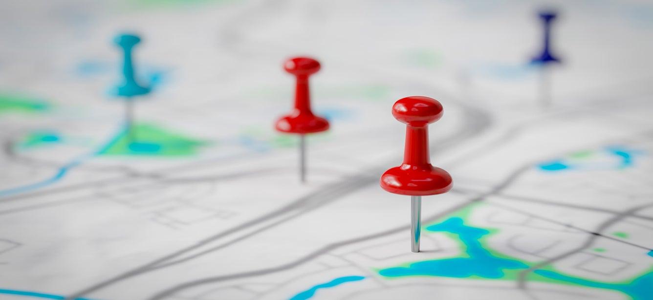 Photo of push pins stuck in a map.