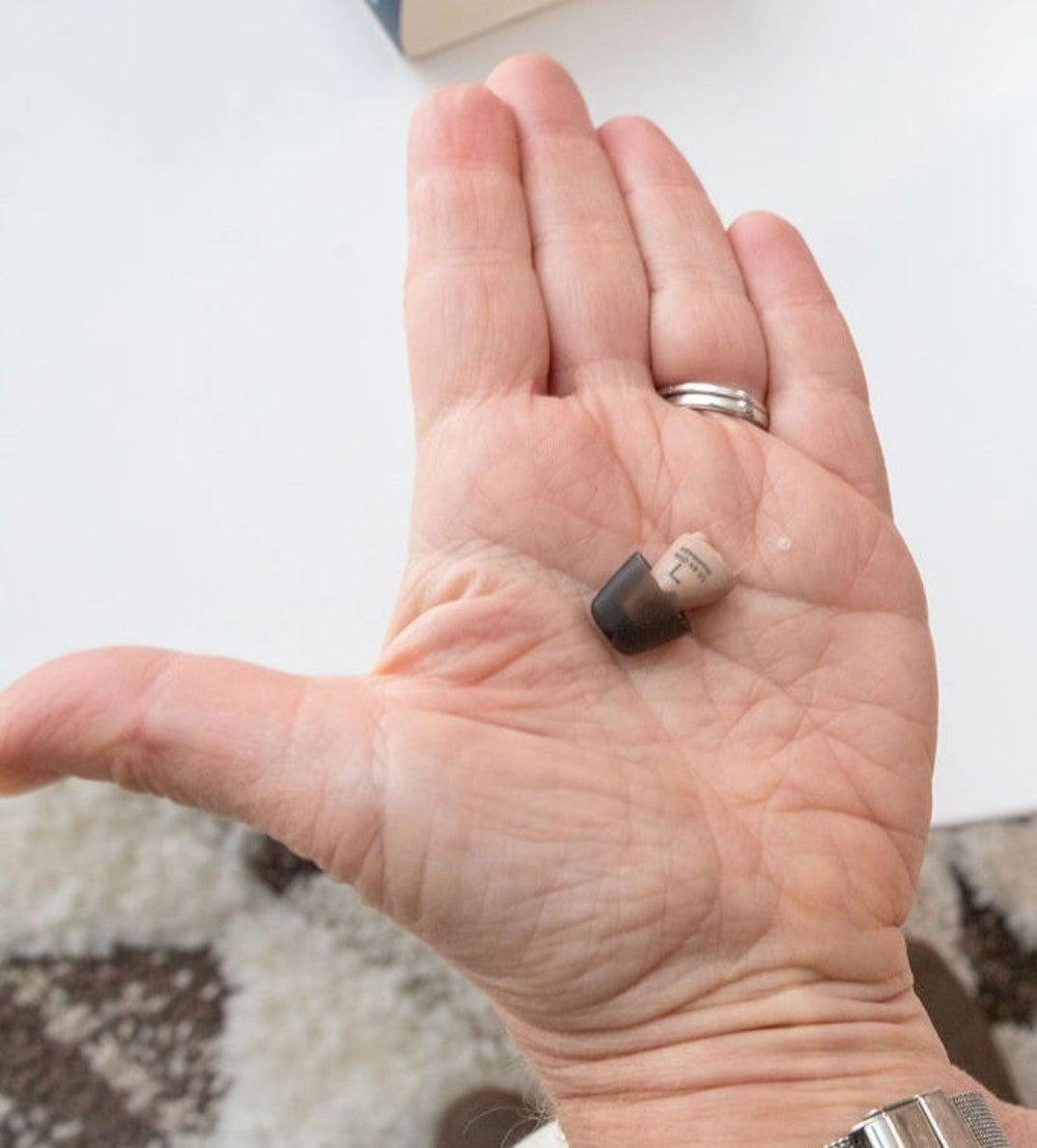 small hearing aid in man's hand