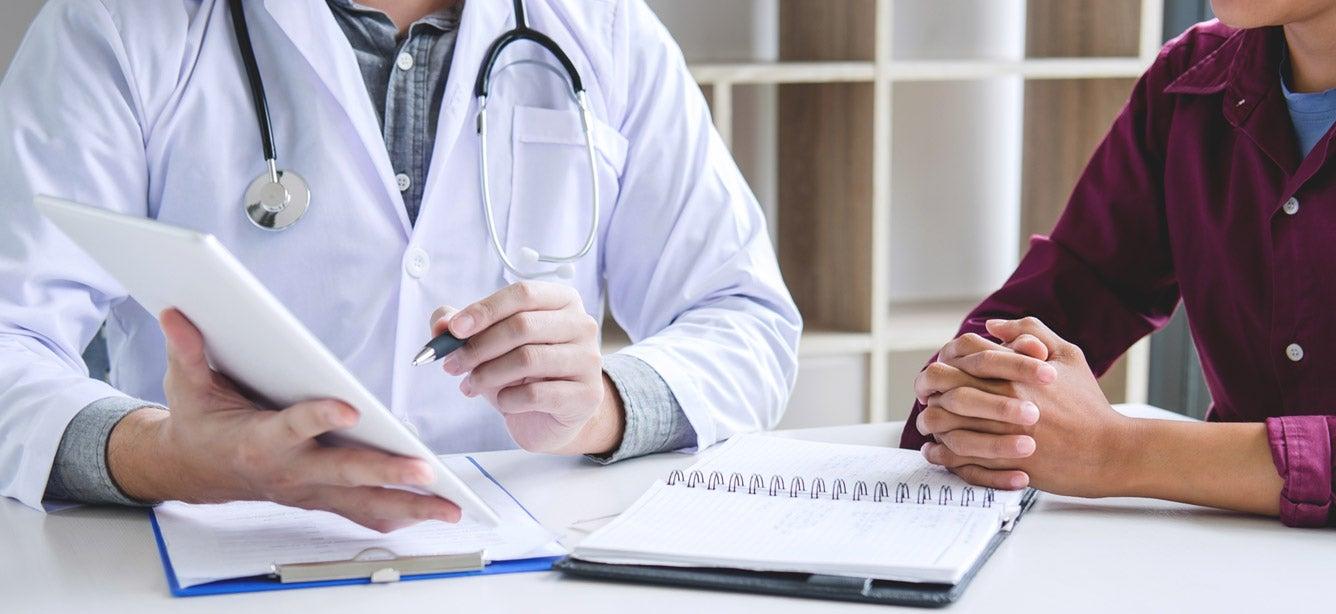 A caucasian male doctor is giving medical advice to his older adult patient.