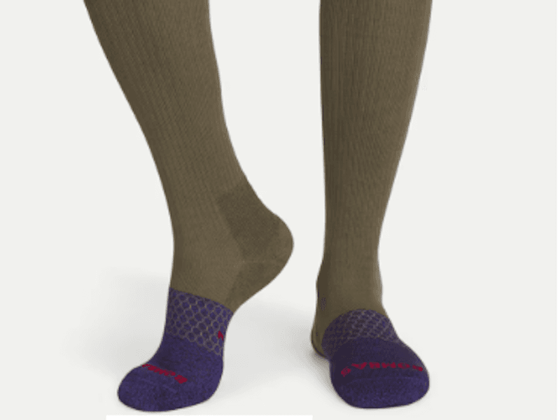 Green knee-high socks with blue toes and “Bombas” logo.