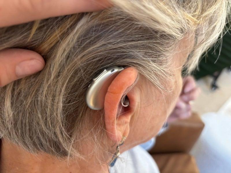 A woman wears the Elehear Beyond Pro hearing aids
